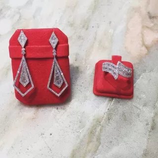 Un paio di orecchini pendenti e un anello in astucci di velluto rosso